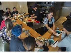 Sushi chef Maumi Ozaki and his wife Yumeko serve sushi to clients at their 10-seat sushi bar in Vancouver.