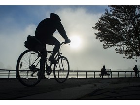 A cyclist bikes along the False Creek seawall.
