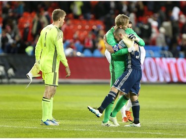 Vancouver Whitecaps Russell Teibert and goalkeeper David Ousted (1) celebrate thier win as Toronto FC goalkeeper Clint Irwin (1) walks pass at the end of MLS action in Toronto on Saturday, May 14, 2016.