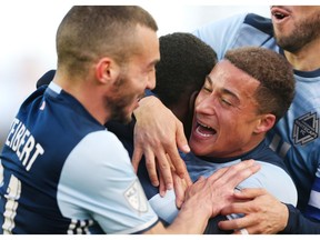 Vancouver Whitecaps forward Erik Hurtado, right, hugs teammate Kekuta Manneh, centre, after Manneh scored against Toronto FC during the first half of MLS action in Toronto on Saturday, May 14, 2016.