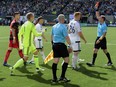Referee issues a red card to Vancouver Whitecaps defender Kendall Watson as defender Tim Parker (26) looks on.