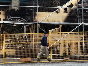 On Monday, a firefighter walks past a condo construction site damaged by fire Sunday that left 100 people homeless, near Johnston Road and Buena Vista Avenue, in the Five Corners area of White Rock. Nick Procaylo/PNG