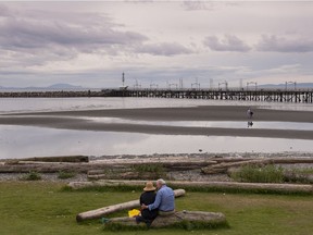A couple enjoys a moment on a quiet day in White Rock on Wednesday. Following the recent condo fire in the city, renewed talk of amalgamation with Surrey has started. Richard Lam/PNG
