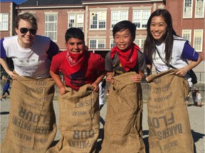 Telus' Nicole MacLellan (left) with two Beaconsfield students and Rita Fung of the Hyatt Regency Hotel taking part in a sack race at Beaconsfield Elementary's family day.