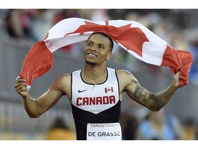 Toronto sprint star Andre De Grasse, who will race in Vancouver Friday night, holds the Canadian flag after he won the gold medal in the men's 100m final at the 2015 Pan Am Games in Toronto.