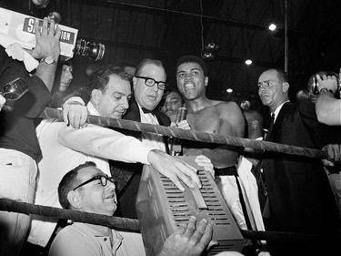 FILE - In this May 25, 1965, file photo, heavyweight champion Muhammad Ali, center right, is interviewed after knocking out of challenger Sonny Liston in the first round of their title fight in Lewiston, Maine. The bout produced one of the strangest finishes in boxing history as well as one of sportsí most iconic moments. (AP Photo/File) ORG XMIT: POS2016060317071848      Muhammad Ali options ORG XMIT: POS1606031709130304