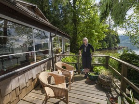 Jo Ledingham stands on the porch of her Belcarra cottage in 2013. The future of her home and six other cottages is in question as Metro Vancouver starts a "planning process" to look at ways to open up Belcarra Regional Park.