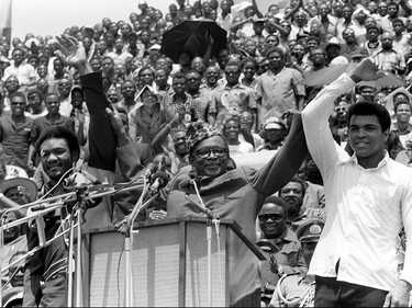 FILE - This is a  Sept. 22, 1974 file photo of Zaire's President Mobutu Sese Seko, center, as he raises the arms of heavyweight champ George Foreman, left, and Muhammad Ali, right, in Kinshasa,  Zaire. It was 40 years ago that two men met just before dawn on Oct. 30, 1974, to earn $5 million in the Rumble in the Jungle. In one of boxing's most memorable moments, Muhammad Ali stopped the fearsome George Foreman to recapture the heavyweight title in the impoverished African nation of Zaire. (AP Photo/Horst Faas, File) ORG XMIT: POS2014103012385637      Muhammad Ali options ORG XMIT: POS1606031709140305