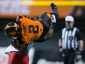 B.C. Lions' Chris Rainey is upended by Calgary Stampeders' Brandon Smith, back, after making a reception during the second half of Saturday's game at B.C. Place.