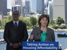 British Columbia Finance Minister Michael de Jong, left, looks on as Premier Christy Clark makes an announcement during a news conference in Vancouver, B.C., Wednesday, June, 29, 2016. Premier Clark announced that the government will end the industry self-regulation in the real estate industry in the province.