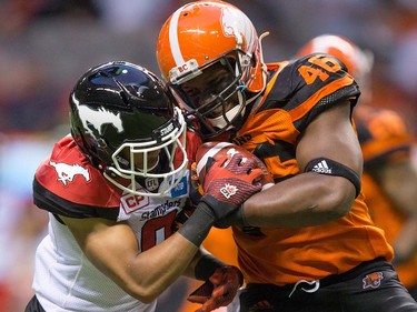 B.C. Lions' Rolly Lumbala, right, is stopped by Calgary Stampeders' Ciante Evans during the second half of a pre-season CFL football game in Vancouver, B.C., on Friday June 17, 2016. THE CANADIAN PRESS/Darryl Dyck ORG XMIT: VCRD130