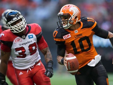 B.C. Lions' quarterback Jonathon Jennings, right, is chased by Calgary Stampeders' Charleston Hughes during the first half of a pre-season CFL football game in Vancouver, B.C., on Friday June 17, 2016. THE CANADIAN PRESS/Darryl Dyck ORG XMIT: VCRD122