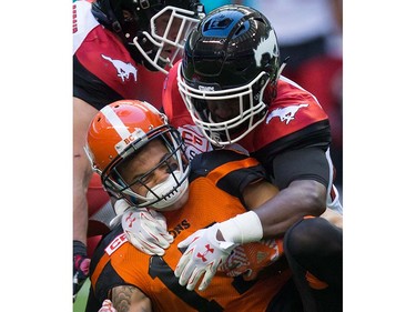 Calgary Stampeders' Jamar Wall, right, tackles B.C. Lions' Nick Moore during the first half of a pre-season CFL football game in Vancouver, B.C., on Friday June 17, 2016. THE CANADIAN PRESS/Darryl Dyck ORG XMIT: VCRD121