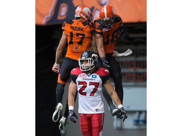 Calgary Stampeders' Jeff Hecht, front, walks to the bench as B.C. Lions' Nick Moore, back left, and Bryan Burnham celebrate Burnham's touchdown during the first half of a pre-season CFL football game in Vancouver, B.C., on Friday June 17, 2016. THE CANADIAN PRESS/Darryl Dyck ORG XMIT: VCRD116
