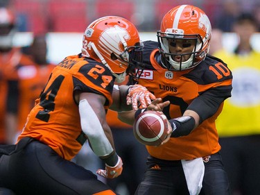 B.C. Lions quarterback Jonathon Jennings, right, hands off to Jeremiah Johnson during the first half of a pre-season CFL football game against the Calgary Stampeders in Vancouver, B.C., on Friday June 17, 2016. THE CANADIAN PRESS/Darryl Dyck ORG XMIT: VCRD115