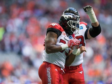 Calgary Stampeders' Jerome Messam, front, and Roman Grozman celebrate Messam's touchdown against the B.C. Lions during the first half of a pre-season CFL football game in Vancouver, B.C., on Friday June 17, 2016. THE CANADIAN PRESS/Darryl Dyck ORG XMIT: VCRD113