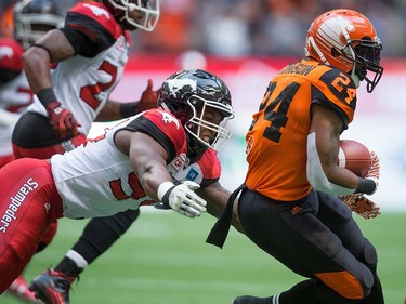 B.C. Lions' Jeremiah Johnson, right, gets away from Calgary Stampeders' Frank Beltre while carrying the ball during the first half of a pre-season CFL football game in Vancouver, B.C., on Friday June 17, 2016. THE CANADIAN PRESS/Darryl Dyck ORG XMIT: VCRD110