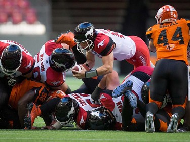 Calgary Stampeders quarterback Andrew Buckley, centre, dives past B.C. Lions' Adam Bighill (44) for a first down during the first half of a pre-season CFL football game in Vancouver, B.C., on Friday June 17, 2016. THE CANADIAN PRESS/Darryl Dyck ORG XMIT: VCRD109