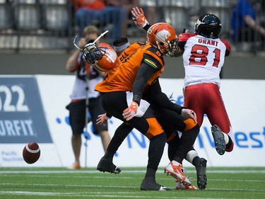 B.C. Lions' Ronnie Yell, back left, loses his helmet as he and Bo Lokombo, front, defend against Calgary Stampeders' Bakari Grant during the first half of a pre-season CFL football game in Vancouver, B.C., on Friday June 17, 2016. THE CANADIAN PRESS/Darryl Dyck ORG XMIT: VCRD108