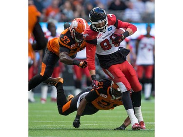 Calgary Stampeders' Simon Charbonneau-Campeau, front right, is brought down by B.C. Lions' Alex Bazzie, left, and Ryan Phillips after making a reception during the first half of a pre-season CFL football game in Vancouver, B.C., on Friday June 17, 2016. THE CANADIAN PRESS/Darryl Dyck ORG XMIT: VCRD106