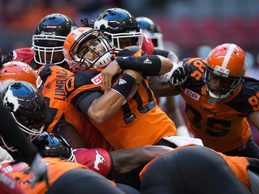 B.C. Lions quarterback Jonathon Jennings, centre, carries the ball for a first down against the Calgary Stampeders during the first half of a pre-season CFL football game in Vancouver, B.C., on Friday June 17, 2016. THE CANADIAN PRESS/Darryl Dyck ORG XMIT: VCRD104