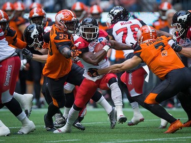 Calgary Stampeders' Roy Finch, centre, is tackled by B.C. Lions' Alex Bazzie (53) and Eric Fraser (7) during the first half of a pre-season CFL football game in Vancouver, B.C., on Friday June 17, 2016. THE CANADIAN PRESS/Darryl Dyck ORG XMIT: VCRD103