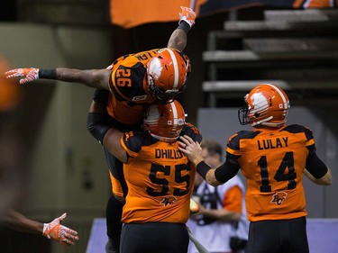 B.C. Lions' Anthony Allen (26), Jaskaran Dhillon (55) and quarterback Travis Lulay (14) celebrate Allen's touchdown against the Calgary Stampeders during the pre-season.
