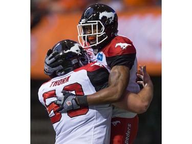 Calgary Stampeders' Bakari Grant, right, and Cam Thorn celebrate Grant's touchdown against the B.C. Lions during the second half of a pre-season CFL football game in Vancouver, B.C., on Friday June 17, 2016. THE CANADIAN PRESS/Darryl Dyck ORG XMIT: VCRD124