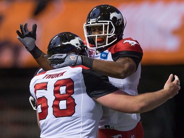 Calgary Stampeders' Bakari Grant, right, and Cam Thorn celebrate Grant's touchdown against the B.C. Lions during the second half of a pre-season CFL football game in Vancouver, B.C., on Friday June 17, 2016. THE CANADIAN PRESS/Darryl Dyck ORG XMIT: VCRD123