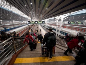 Passengers board trains at Beijing's West Railway Station.
