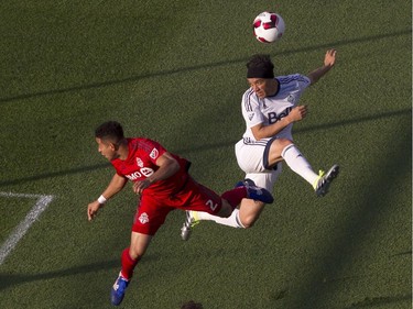 Vancouver Whitecaps' Christian Bolanos, right, tries to direct a header on the goal despite pressure from Toronto FC's Justin Morrow during first half Canadian Cup action in Toronto on Tuesday June 21, 2016.