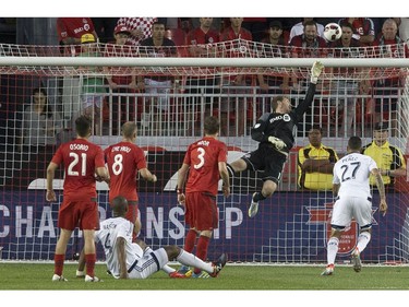 Toronto FC goalkeeper Clint Irwin tips the ball over his net after a header from Vancouver Whitecaps' Kendell Waston (4) during second half Canadian Cup action in Toronto on Tuesday June 21, 2016.