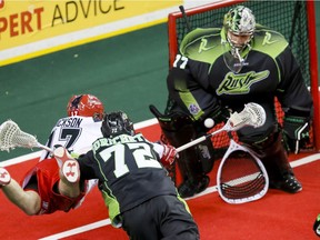 Curtis Dickson of the Roughnecks shoots on Saskatchewan Rush goalie Aaron Bold, with defender Adrian Sorichetti checking Dickson, in Calgary on Jan. 2. Bold has joined the North Shore Indians.