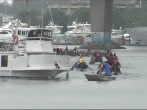 A charter yacht powers into the middle of a dragon boat race in False Creek on Saturday afternoon.