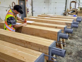 Engineered wood products manufactured for the Brock Commons student residence, an 18-storey mass-timber tower, undergo quality-control inspections at Structurlam Products LP's plant in Penticton. [PNG Merlin Archive]