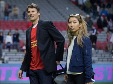 Vancouver Mayor Gregor Robertson, left, and singer-songwriter Wanting Qu leave the field after Robertson presented the man of the match award after Canada and Japan played a rugby test match in Vancouver, B.C., on Saturday June 11, 2016.