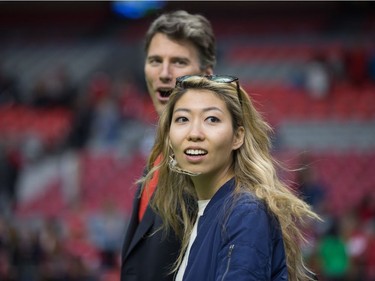Singer-songwriter Wanting Qu, front, and Vancouver Mayor Gregor Robertson, back, leave the field after Robertson presented the man of the match award after Canada and Japan played a rugby test match in Vancouver, B.C., on Saturday June 11, 2016.