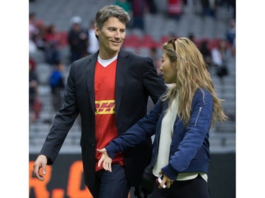 Vancouver Mayor Gregor Robertson, left, and singer-songwriter Wanting Qu leave the field after Robertson presented the man of the match award after Canada and Japan played a rugby test match in Vancouver, B.C., on Saturday June 11, 2016.