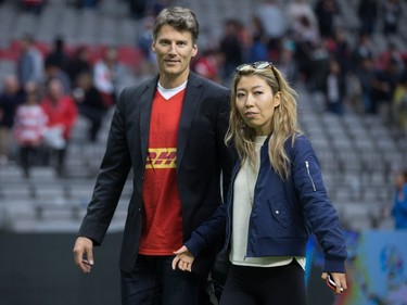 Vancouver Mayor Gregor Robertson, left, and singer-songwriter Wanting Qu leave the field after Robertson presented the man of the match award after Canada and Japan played a rugby test match in Vancouver, B.C., on Saturday June 11, 2016.