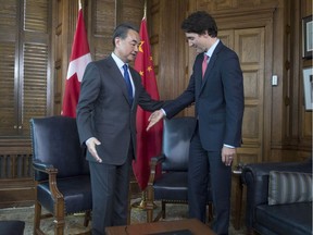 Prime Minister Justin Trudeau (right) gestures to China Foreign Minister Wang Yi to take a seat during the latter’s visit to Ottawa earlier this month.