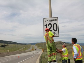 B.C. transportation ministry crews change the speed limit signs in 2014 after the province changed the new maximum speeds on some 1,300 kilometres of rural highways.