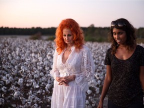 Legendary burlesque dancer Tempest Storm, left, and documentary film director Nimisha Mukerji walk in a Georgia field.