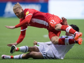 Canada's Marcel De Jong, top, is tackled by Mexico's Hirving Lozano during first half FIFA World Cup qualifying soccer action at B.C. Place in March. He's making a return trip to Vancouver, this time as a member of the Ottawa Fury.