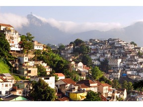 A Rio de Janeiro slum (favela) is shown on the hill at right, contrasted with the more affluent Urca neighbourhood, as viewed from a tram in Santa Teresa. Christ the Redeemer statue is in the far background. — Wikimedia Commons