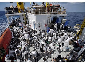In this June 25 photo, migrants sit at the stern of the 'Aquarius' vessel on the Mediterranean Sea. A competition during the Vancouver International Film Festival will award $20,000 for the best short film about refugees.