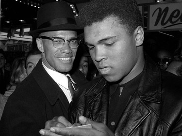 FILE - In this March 1, 1964, file photo, world heavyweight boxing champion, Muhammad Ali, right, is shown with Black Muslim Leader, Malcolm X, outside the Trans-Lux Newsreel Theater  in New York City, after watching a screening of films on Ali's title fight with Sonny Liston in Miami Beach. Ali, the magnificent heavyweight champion whose fast fists and irrepressible personality transcended sports and captivated the world, has died according to a statement released by his family Friday, June 3, 2016. He was 74. (AP Photo) ORG XMIT: NY212