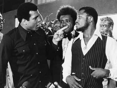 FILE - In this July 17, 1975, file photo, sports promoter Don King stands between Muhammad Ali, left, the heavyweight champion, and Joe Frazier in New York. Ali, the magnificent heavyweight champion whose fast fists and irrepressible personality transcended sports and captivated the world, has died according to a statement released by his family Friday, June 3, 2016. He was 74. (AP Photo/File) ORG XMIT: NY206