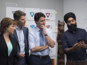 Prime Minister Justin Trudeau, centre, along with British Columbia Premier Christy Clark,left and Vancouver Mayor Gregor Robertson are shown a new app by a Microsoft employee during the opening of Microsoft's new location in Vancouver, Friday, June, 17, 2016.