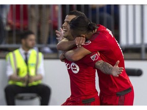 Toronto FC's Sebastian Giovinco, left, is hugged by teammate Mo Babouli after scoring his team's winning goal against the Vancouver Whitecaps in Leg 1 of the Amway Canadian Championship Final in Toronto on Tuesday, June 21, 2016. Game 2 will be played in Vancouver on Wednesday, June 29.