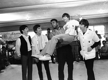 FILE - In this Feb. 18, 1964 file photo, boxer Cassius Clay lifts Beatles member Ringo Starr while the singers visited Clay's camp in Miami Beach, Fla. Others from left are Paul McCartney, George Harrison and John Lennon. A few days earlier the British musicians had appeared for the first time on the Ed Sullivan Show. A week later, Clay would beat Sonny Liston and go on to even greater things as Muhammad Ali. (AP Photo) ORG XMIT: NY353